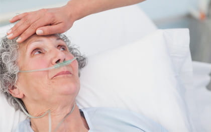 Elderly woman laying in bed receiving 24hr care