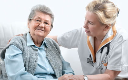 Alzheimer's patient sitting with her caregiver