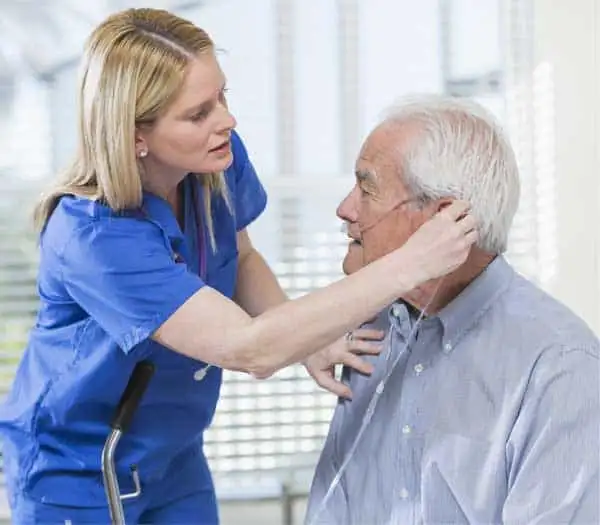 Personal Home Care Caregiver assisting elderly man with oxygen